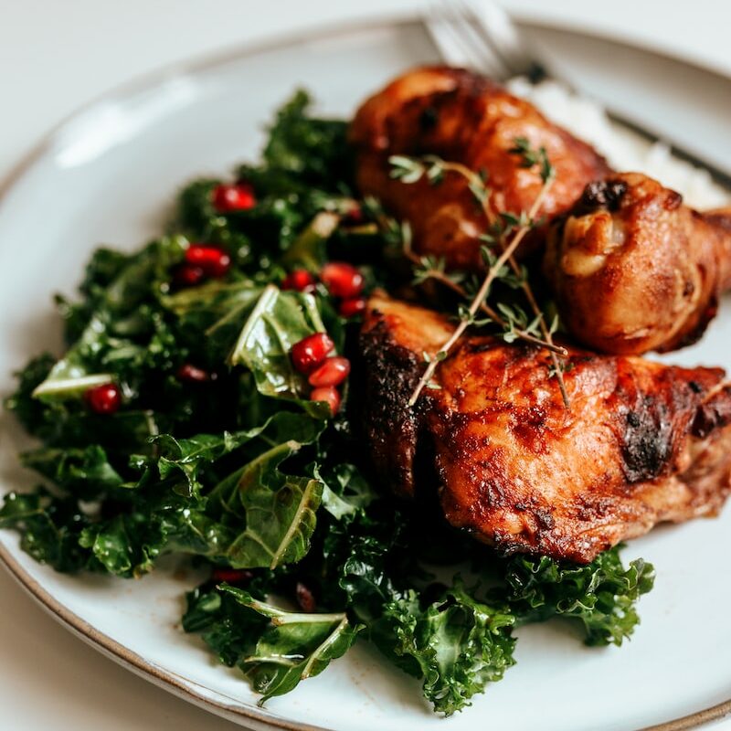 cooked meat with green vegetable on white ceramic plate